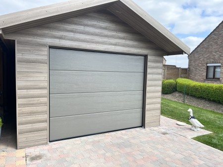 Sectionale poort gemonteerd in een tuin garage Langemark - Poelkapelle